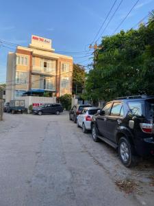 a parking lot with cars parked in front of a building at MINH THU MOTEL in Quảng Ngãi