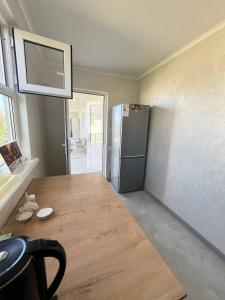 a kitchen with a wooden table and a refrigerator at Kabyl Guest House in Tossor +4 photos