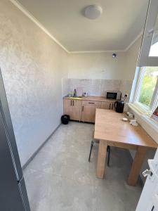 a kitchen with a wooden table and a desk at Kabyl Guest House in Tossor