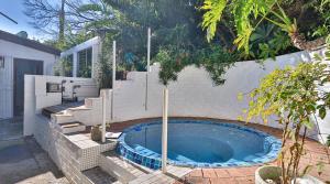 a small swimming pool in a backyard with a fence at Private Retreat in Gordonʼs Bay