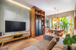 a living room with a flat screen tv on a wall at Villa Dinova in Uluwatu