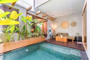 a swimming pool in a room with plants at Villa Dinova in Uluwatu