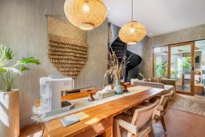 a dining room with a table with a coffee machine at Villa Dinova in Uluwatu