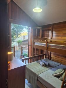 a bedroom with a bunk bed with a desk and a window at Chalé Veraneio-Itú-SP Vista para o lago Camping Carrion in Itu +115 photos