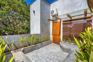 a building with a wooden door and some plants at Villa Dinova in Uluwatu