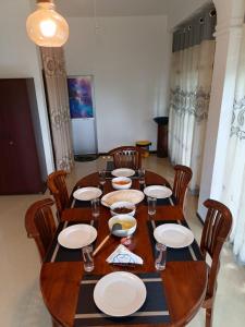 a wooden table with chairs and plates on it at Villa Deniyaya in Deniyaya +22 photos