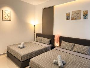 a bedroom with two beds and a lamp at Atlantis Residences by UVM Stay -4 Pax in Malacca +55 photos