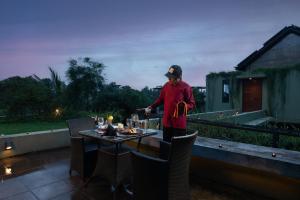 a man standing on a balcony with a table at Villa 98 in Malabe