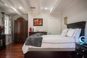a bedroom with a large bed with white sheets at National Harbor Suite 1 in Fort Washington