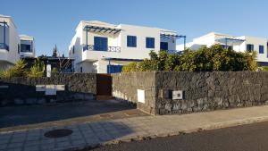 een stenen muur naast een paar witte huizen bij VILLA DUNIA by Villitas in Playa Blanca