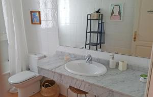 een badkamer met een wastafel, een toilet en een spiegel bij VILLA DUNIA by Villitas in Playa Blanca +23 foto's