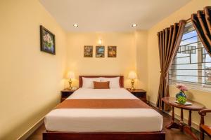 a bedroom with a large bed and a window at Vina Boutique Hotel in Hue