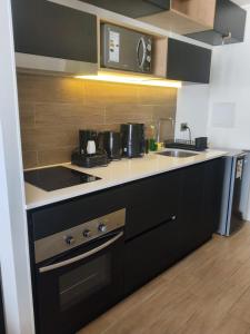 a kitchen with a sink and a stove top oven at Despierta con una vista impecable cada mañana in Coquimbo