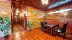 a dining room with wooden walls and a table and chairs at Cloudy Hill Homestay and Hostel in Kampot