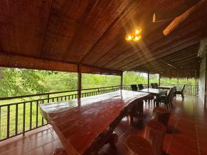 a large wooden table and chairs on a balcony at Cloudy Hill Homestay and Hostel in Kampot