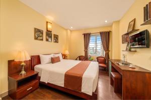 a hotel room with a bed and a desk at Vina Boutique Hotel in Hue