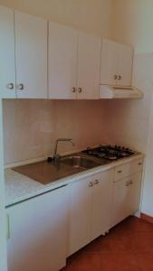 una cucina bianca con lavandino e piano cottura di Cala Rossa Dream a Favignana