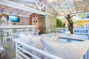 a patio with tables and chairs and a bar at Luxury Villa Fotini in Limenas