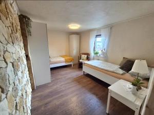 a room with two beds and a stone wall at Wohnung beim Kodderey ruhig und herzlich in Neuhof