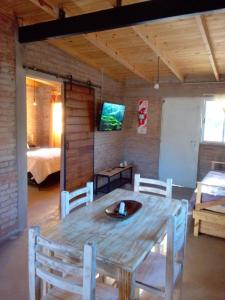 a dining room with a table and chairs and a bedroom at Refugio de Monte in San Luis