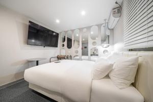 a white room with a bed and a table at 구리 호텔 옐로 in Guri