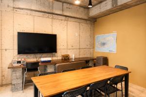 ein Konferenzraum mit Tisch und Flachbildfernseher in der Unterkunft 수스테이 펜션 in Seogwipo