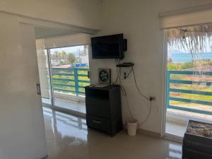 a living room with a television and a door to a balcony at DEPARTAMENTO SOL Y MAR in San Carlos
