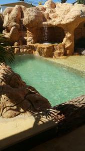 une piscine d'eau avec une cascade et des rochers dans l'établissement Hospedaje Solymar Sarie Bay, à San Andrés