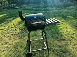 a grill sitting on a stand in the grass at Väänavilla Romantic Getaway in Vääna-Jõesuu