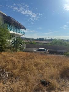 a car parked in a field next to a building at DEPARTAMENTO SOL Y MAR in San Carlos