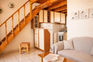 a living room with a couch and a kitchen at STUDIOS ATHENA in Megalochori +28 photos