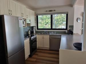 a kitchen with white cabinets and a large window at Salty Dog in Long Beach +9 photos