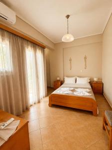 a bedroom with a bed and a large window at STUDIOS ATHENA in Megalochori