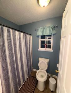 a bathroom with a toilet and a window at The Universal Home Stay in Akron