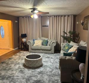 a living room with two couches and a coffee table at The Universal Home Stay in Akron