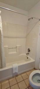 a bathroom with a white tub and a toilet at Albuquerque Inn in Albuquerque
