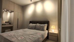 a small bedroom with a bed and a lamp at RINA HOMESTAY Kemaman in Cukai +5 photos