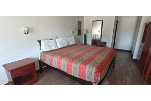 a hotel room with a bed and a table at Albuquerque Inn in Albuquerque