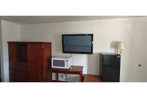 a living room with a television and a microwave at Albuquerque Inn in Albuquerque +2 photos