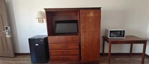 a large wooden cabinet with a television and a desk at Albuquerque Inn in Albuquerque