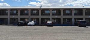 a building with cars parked in a parking lot at Albuquerque Inn in Albuquerque