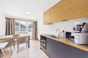 a kitchen with a sink and a table with chairs at Alpine Apartment near Saas-Fee for 4 in Saas-Almagell