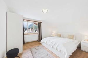 a white bedroom with a white bed and a window at Alpine Apartment near Saas-Fee for 4 in Saas-Almagell