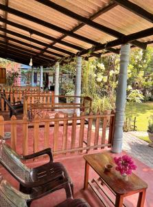 a porch with a bench and a table with flowers at Lobster Inn in Trincomalee