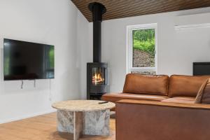 a living room with a couch and a fireplace at Newly Renovated Cottage With Sauna in Melby