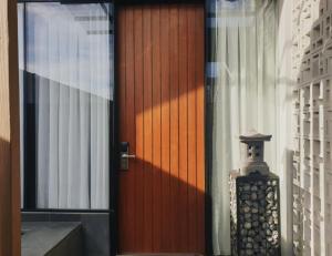 a red door with a statue in front of it at R7 Cottages Pangandaran in Cikembulan