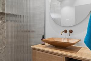 a bathroom with a wooden sink and a mirror at Newly Renovated Cottage With Sauna in Melby