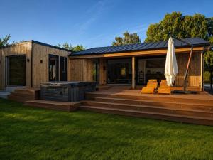 a house with a deck with an umbrella at Newly Renovated Cottage With Sauna in Melby