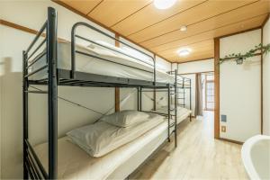 a bunk bed room with two bunk beds in it at Guesthouse Ichiedo in Kashihara