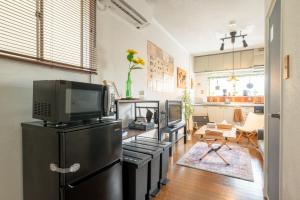a living room with a tv on top of a refrigerator at Guesthouse Ichiedo in Kashihara
